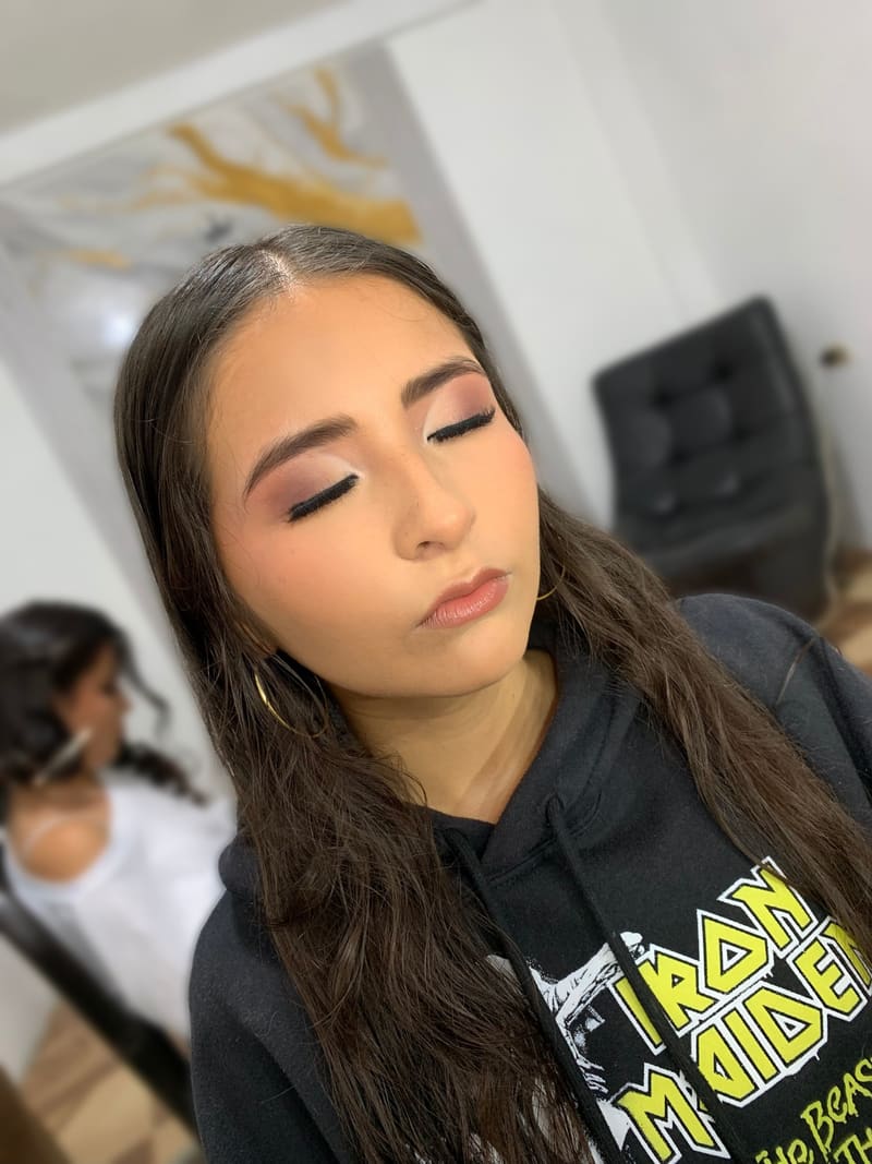 Maquillaje en tonos ciruela con pestañas definidas y labios nude